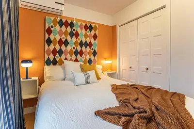 a bedroom with a bed with a blanket on it at 119 - Vibrant Chic Designer 2BR with Gym,Parking,Airport&DT in Montréal