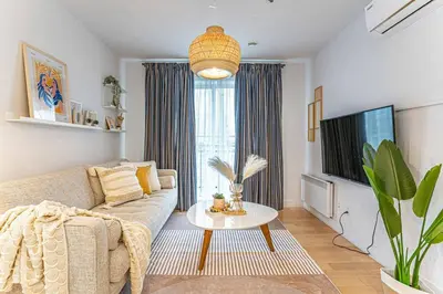 a living room with a couch and a tv at 119 - Vibrant Chic Designer 2BR with Gym,Parking,Airport&DT in Montréal