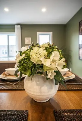 a vase filled with white flowers on a table at 201 - Comfy Spacious 2BR Apt with Gym, Parking, DT&Airport in Montréal