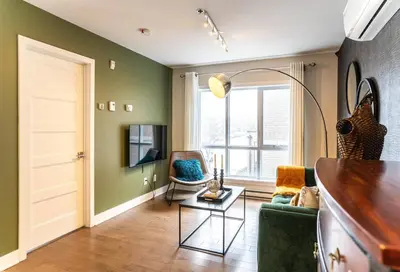 a living room with green walls and a table and chairs at 201 - Comfy Spacious 2BR Apt with Gym, Parking, DT&Airport in Montréal