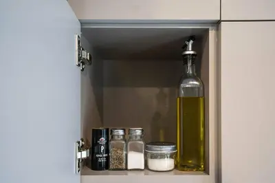 a cabinet with a bottle of oil and spices at 201 - Comfy Spacious 2BR Apt with Gym, Parking, DT&Airport in Montréal