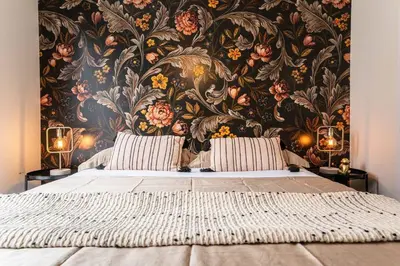 a bedroom with a large bed with a floral wallpaper at 201 - Comfy Spacious 2BR Apt with Gym, Parking, DT&Airport in Montréal
