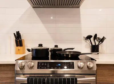 two pots and pans on a stove in a kitchen at 202 - Modern Exquisite Suite with Gym,Parking, near DT&Airport in Montréal