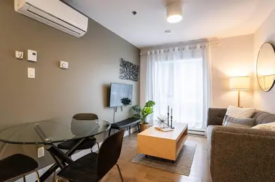 a living room with a glass table and a couch at 202 - Modern Exquisite Suite with Gym,Parking, near DT&Airport in Montréal