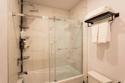 a shower with a glass door in a bathroom at 202 - Modern Exquisite Suite with Gym,Parking, near DT&Airport in Montréal