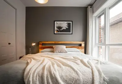 a bedroom with a large bed and a window at 202 - Modern Exquisite Suite with Gym,Parking, near DT&Airport in Montréal