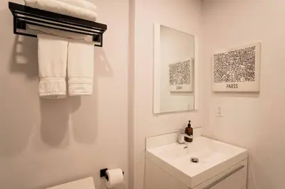 a white bathroom with a sink and a mirror at 202 - Modern Exquisite Suite with Gym,Parking, near DT&Airport in Montréal