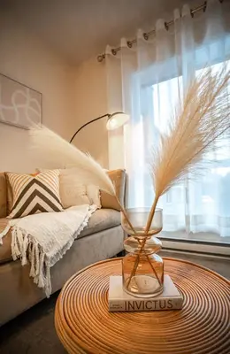 a living room with a table with a vase with feathers at 203 - Fantastic Cozy New 2 Queen Condo with Gym, DT&Airport in Montréal