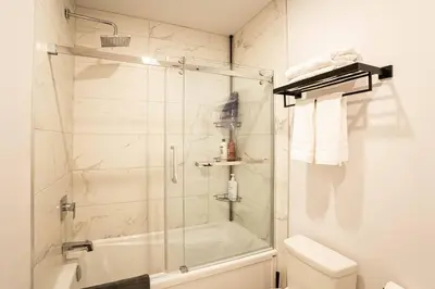 a bathroom with a shower with a glass door at 207 - Mondern Cozy New Apt with 2BR, Prking, Gym,DT&Airport in Montréal