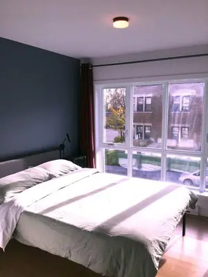 a bedroom with a bed and a large window at 208 - Modern Cozy Bright Apt with 2BR,Gym,Prking,DT&Airport in Montréal