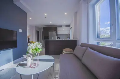 a living room with a couch and a table at 208 - Modern Cozy Bright Apt with 2BR,Gym,Prking,DT&Airport in Montréal