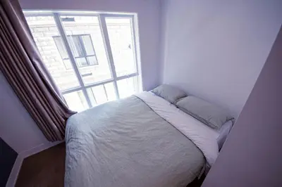 a bed in a room with a large window at 208 - Modern Cozy Bright Apt with 2BR,Gym,Prking,DT&Airport in Montréal