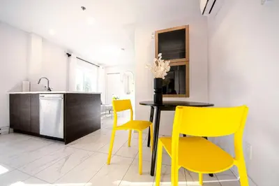 a dining room with yellow chairs and a table at 208 - Modern Cozy Bright Apt with 2BR,Gym,Prking,DT&Airport in Montréal