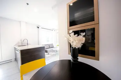 a living room with a vase of flowers on a table at 208 - Modern Cozy Bright Apt with 2BR,Gym,Prking,DT&Airport in Montréal