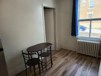 a table and two chairs in a room with a window at Iphigenie in Montréal
