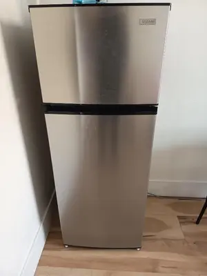 a stainless steel refrigerator in a corner of a room at Iphigenie in Montréal
