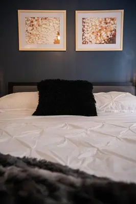 a white bed with two pictures on the wall at 209 - Modern Home Ambiance 2 BR with Gym,Parking,DT&Airport in Montréal
