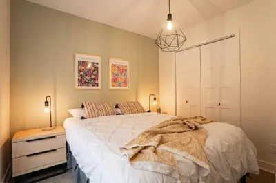 a bedroom with a large white bed and two lamps at 209 - Modern Home Ambiance 2 BR with Gym,Parking,DT&Airport in Montréal