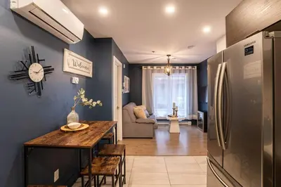 a kitchen and living room with a table and a refrigerator at 209 - Modern Home Ambiance 2 BR with Gym,Parking,DT&Airport in Montréal
