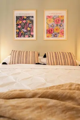 a large white bed with two pictures on the wall at 209 - Modern Home Ambiance 2 BR with Gym,Parking,DT&Airport in Montréal