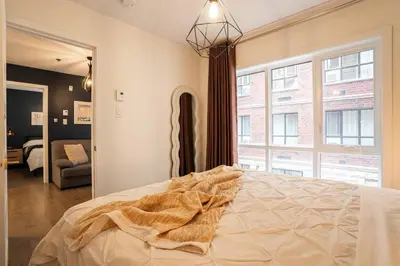 a bedroom with a bed and a large window at 209 - Modern Home Ambiance 2 BR with Gym,Parking,DT&Airport in Montréal