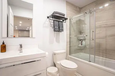 a bathroom with a toilet and a sink and a shower at 210 - Fantastic Neat 2BR with Parking, Gym, near DT&Airport in Montréal