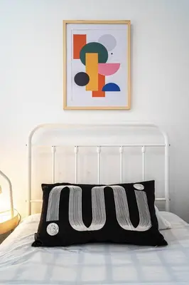 a bed with a black and white pillow on it at 210 - Fantastic Neat 2BR with Parking, Gym, near DT&Airport in Montréal