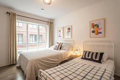 two beds in a room with a window at 210 - Fantastic Neat 2BR with Parking, Gym, near DT&Airport in Montréal