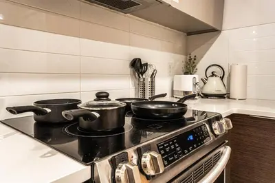 a stove with pots and pans on it in a kitchen at 211 - Cozy New Condo with 2 Queens, Parking, DT&Airport in Montréal