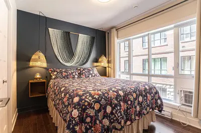 a bedroom with a bed and a large window at 214 - Boho Ambiance Designer 2BR with Gym,Prking,DT&Airport in Montréal