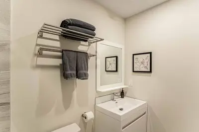 a white bathroom with a sink and a mirror at 214 - Boho Ambiance Designer 2BR with Gym,Prking,DT&Airport in Montréal