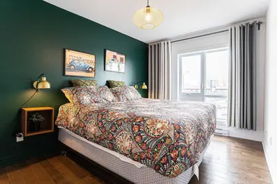 a bedroom with a bed and a green wall at 218 - Emerald Retro KING Suite with Parking, Gym,DT&Airport in Montréal