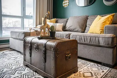 a living room with a couch and a trunk at 218 - Emerald Retro KING Suite with Parking, Gym,DT&Airport in Montréal