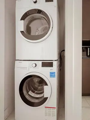 a white washer and dryer in a room at 218 - Emerald Retro KING Suite with Parking, Gym,DT&Airport in Montréal