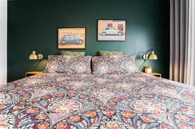 a bedroom with a bed with two lamps and two paintings at 218 - Emerald Retro KING Suite with Parking, Gym,DT&Airport in Montréal