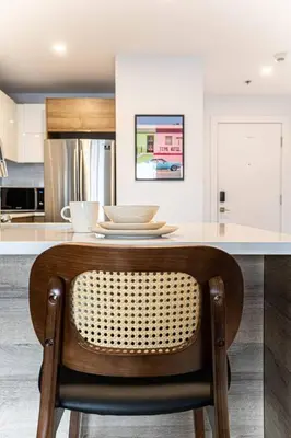 a kitchen with a counter with a chair at a table at 218 - Emerald Retro KING Suite with Parking, Gym,DT&Airport in Montréal