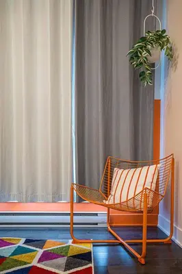 a chair sitting in front of a window with a plant at 219 - Abstract Designer King Suite with Parking, DT&Airport in Montréal