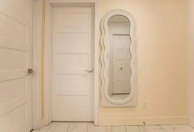 a white door with a mirror on a wall at 219 - Abstract Designer King Suite with Parking, DT&Airport in Montréal