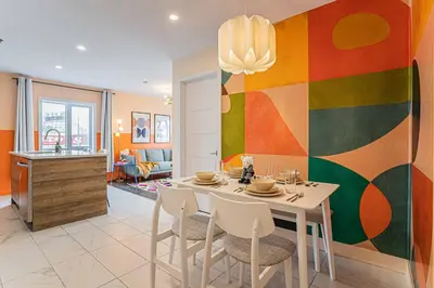 a dining room with a table and chairs and a colorful wall at 219 - Abstract Designer King Suite with Parking, DT&Airport in Montréal
