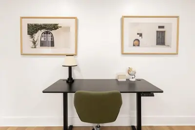 a black desk with a green chair and two pictures at The Samson Haven in Laval
