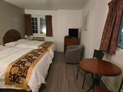 a bedroom with a bed and a desk and a table at Motel châteauterrebonne in Terrebonne