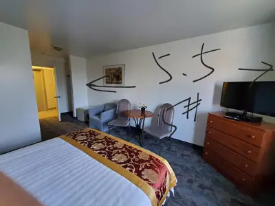 a bedroom with a bed and a tv and a table at Motel châteauterrebonne in Terrebonne