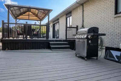 a grill on a deck next to a building at Residence Havre d'abraham in Laval