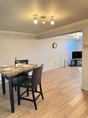 a dining room with a table and a clock on the wall at Residence Havre d'abraham in Laval