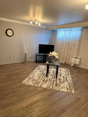a living room with a coffee table and a tv at Residence Havre d'abraham in Laval