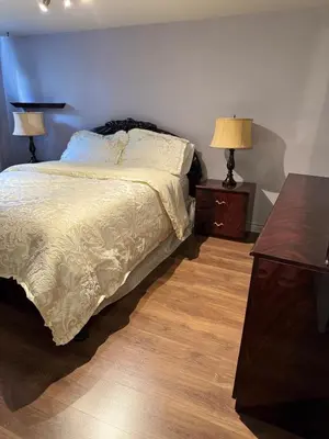 a bedroom with a bed and two night stands at Residence Havre d'abraham in Laval