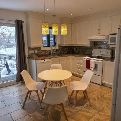 a kitchen with a table and chairs in it at Appartement cosy, comme à la maison in Montréal