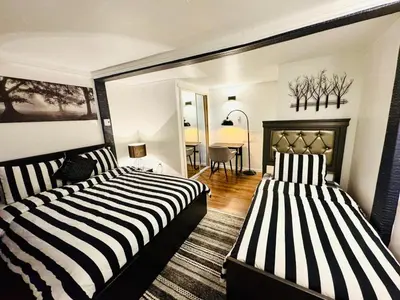two beds in a room with a living room at Linda inn - Entire Unit- Sleep 3- Sherbrooke in Sherbrooke