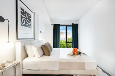 a white bedroom with a white couch and a window at La Parisienne in Old Montreal -Downtown Montreal - Laundry in Montréal