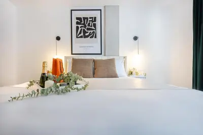 a bedroom with a large white bed with a flower arrangement on it at La Parisienne in Old Montreal -Downtown Montreal - Laundry in Montréal